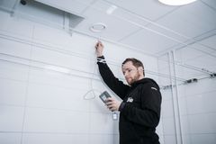 Mies tarkistaa ilmastointijärjestelmää sisätiloissa LVI-Trio-yrityksen työasussa.
