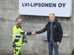 Alt-teksti: Kaksi henkilöä kättelee muurirakennuksen edessä, jossa on kyltti "LVI-Lipsonen Oy".