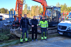 Petri Peltoniemi, Janne Korhonen ja Kalle Kaski seisovat kaivinkoneen edessä tietoliikenneverkkotyömaalla.