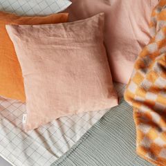 Oranssin ja persikan sävyt lämmittävät sisustusta. Kuvassa Anno Viive tyynynpäällinen sävyissä Persikka ja Oranssi.