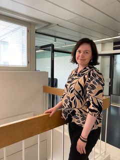 Vuoden tutkija -arvonimellä palkittu Erika Jääskeläinen seisoo sairaalan käytävällä portaikon kaiteen vieressä.