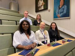 Terttu-säätiön palkitsemat tohtorikoulutettavat ryhmäkuvassa. Neljä naista ja yksi mies istuvat luentosalin vihreillä penkeillä kahdessa rivissä.