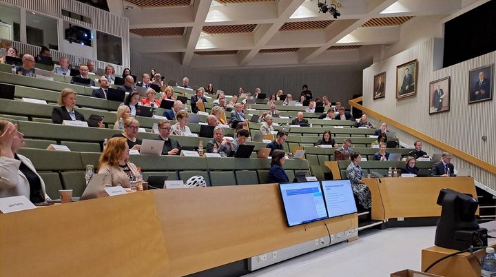 Kuva Pohteen aluevaltuuston kokoussalista, jossa valtuutetut istuvat paikoillaan.