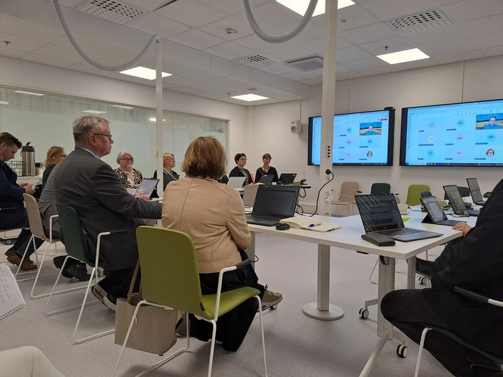 Kuva kokoushuoneesta, jossa tulevaisuuslautakunnan jäseniä istuu pöydän äärellä.