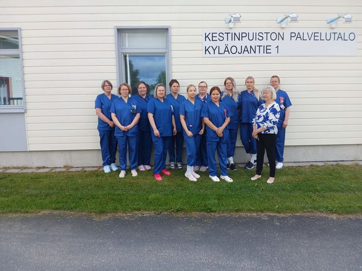 Nivalan palvelukoti Kestinpuiston henkilöstö yhteiskuvassa palvelukodin edessä.