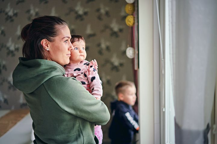 Nainen ja vauva katsovat ikkunasta ulos.