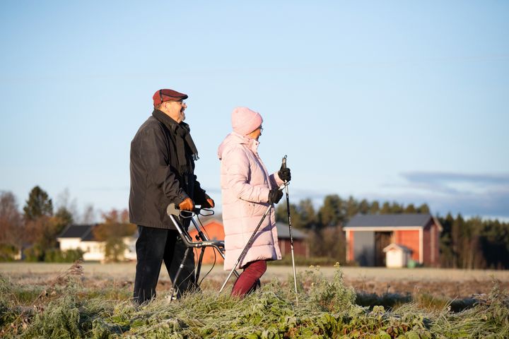 Kaksi ikäihmistä ulkona kävelyllä.