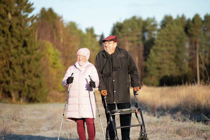 Kaksi ikäihmistä syysmaisemissa.