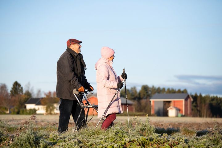 Kaksi ikäihmistä kävelyllä ulkona.