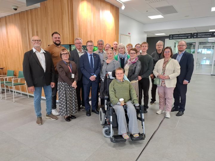 Aluehallituksen jäseniä ja vaikuttamistoimielinten puheenjohtajat ryhmäkuvassa sairaalan käytävällä.