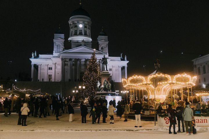 Kuvassa Tuomaan Markkinat kuvattuna pimeän aikaan. Etualalla karusellin loistavat valot ja takana Tuomiokirkko valaistuna.