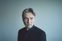 Kuvassa Esa-Pekka Salonen vaaleansinistä taustaa vasten mustaan puvuntakkiin pukeutuneena.