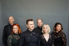 Kuusi  Rajattoman jäsentä seisomassa harmaata taustaa vasten.