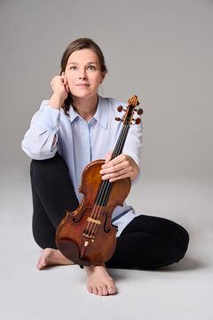 Janine Jansen istuu lattialla pitäen viulua sylissään.