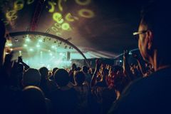 Esiintyjä lavalla valaistussa juhlateltassa yleisön edessä.