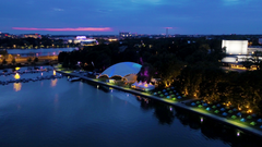 Ilmakuva vedestä ja Huvilasta, jonka ympärillä on valaistuja telttoja illalla.