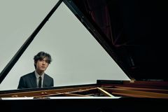 Kuvassa pianisti Yunchan Lim istuu flyygelin ääressä.