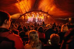 Katie Melua konsertoimassa täydessä Huvila-teltassa, oranssit valot lavalla.