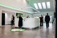 Pankkikonttorista näkymä, keskellä valkoinen infotiski, jonka ympärillä asioivia.