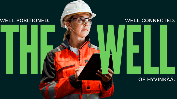 Henkilö rakennustyöntekijän asussa, suojakypärä ja suojalasit yllään, pitää taulutietokonetta kädessään. Taustalla teksti "Well Positioned. Well Connected. The Well of Hyvinkää."