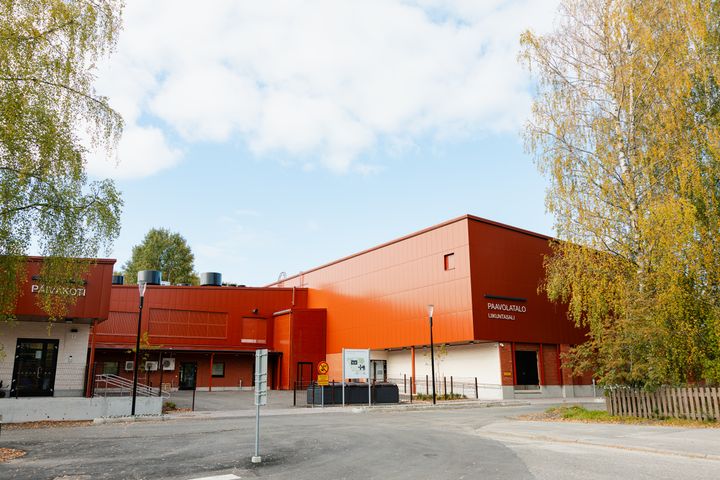 Paavolatalon punainen rakennus, puita ympärillä.