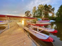Punavalkoinen vesitaso on laiturin vieressä järvellä auringonlaskun aikaan.