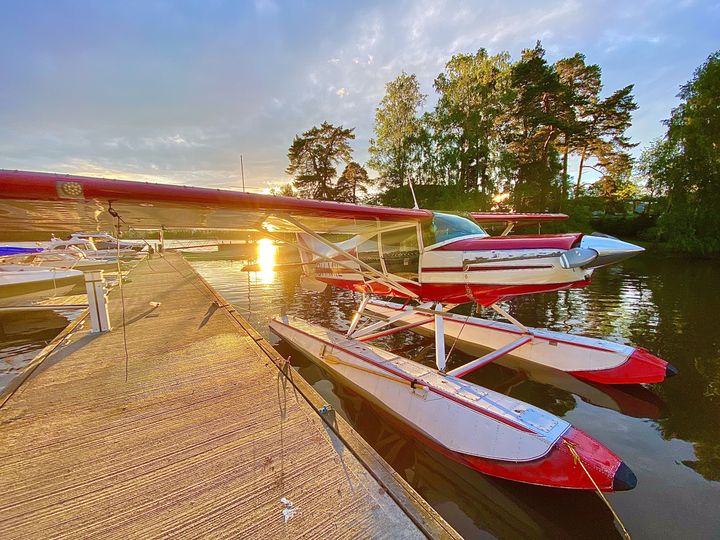 Punavalkoinen vesitaso on laiturin vieressä järvellä auringonlaskun aikaan.