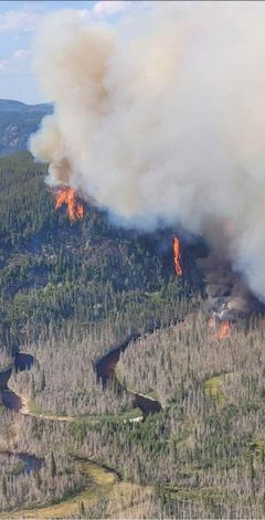 Ilmakuva metsäpalosta, josta näkyy kolmessa eri kohtaa liekkejä. Palon keskellä kiemurtelee joki. Savu nousee isona patsaana taivaalle.
