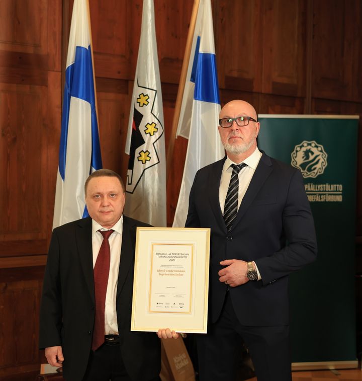 Markku Kumpulainen ja Kai Kieränen käsissään kehyksissä oleva Sosiaali- ja turvallisuusalan turvallisuuspalkinto.