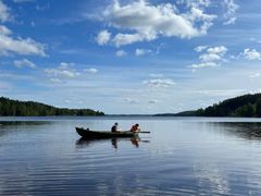 Järvellä seutuvene ja kaksi ihmistä.
