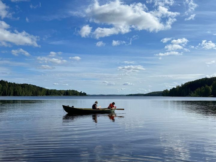 Järvellä seutuvene ja kaksi ihmistä.
