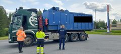 Kolme viranomaista tarkastaa jätekuljetusrekkaa pysäköintialueella.
