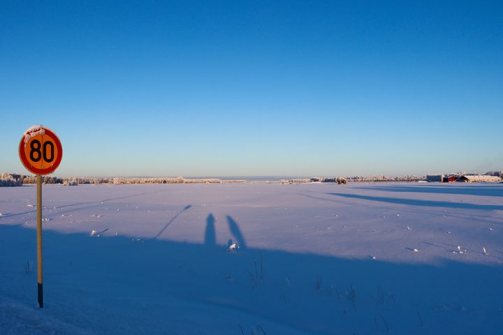 Nopeusrajoituksen liikennemerkki 80 km/h talvisessa maisemassa.