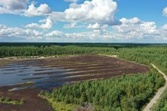 Sommarluftfoto av ett tidigare torvproduktionsområde som delvis har blivit vattenfyllt. I nedre kanten av bilden finns EU-flaggan och texten Medfinansieras av Europeiska unionen.