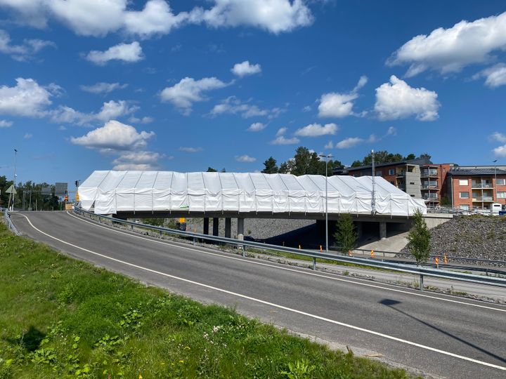 Kuvassa Palosaaren ja Vetokannaksen yhdistävä risteyssilta työn alla. Kuvassa on kesäinen sää ja keskellä näkyy huputettu silta.