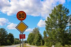 Tie, jossa on nopeusrajoitus 80 km/h, varoituskolmio ja numero 16 kyltti. Taustalla puita ja pilvinen taivas.