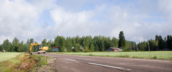 Maaseudulla kaivinkone kaivaa tien viereen maahan ojaa laajakaistajohdoille.
