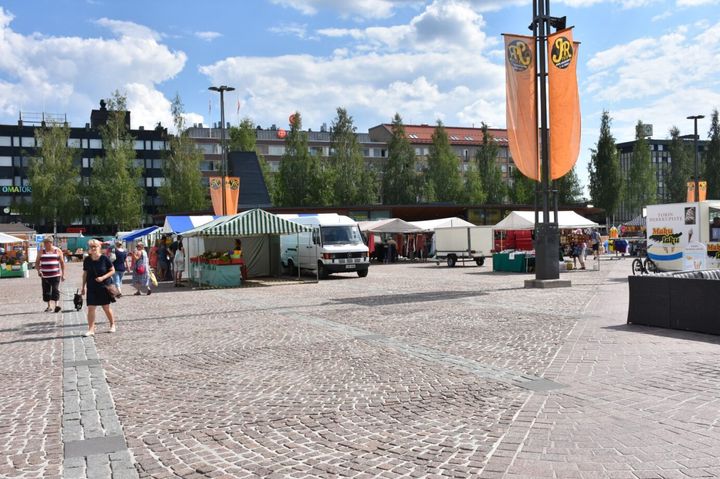 Mikkelin tori kesällä. Etualalla torin pintaa, taustalla ihmisiä ja torikojuja