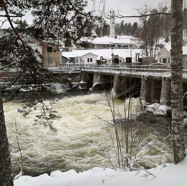 Virtaileva patoallas, jossa vesi on vapaana, vaikka ympäristö on jäinen ja luminen.