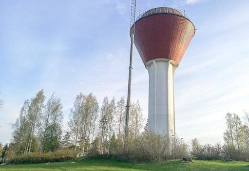 Juvan vesitorni, sitä lyhyempiä puita ja vaaleansininen taivas