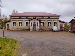 Vanha vaalea huonokuntoinen puurakennus.
