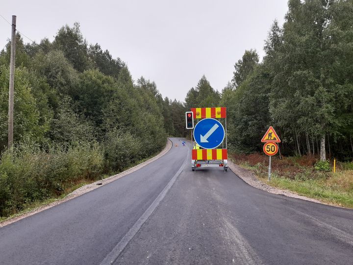 Liikenteenohjausvaunu tiellä, jossa nopeusrajoitus 50 km/h. Taustalla metsää.