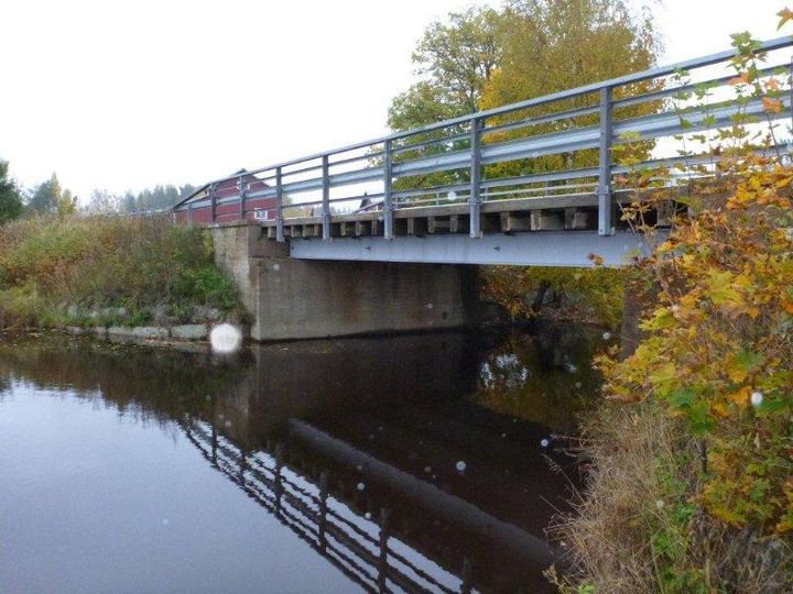 Silta, joka kulkee veden yllä Virolahdella, ympärillä syksyisiä puita.