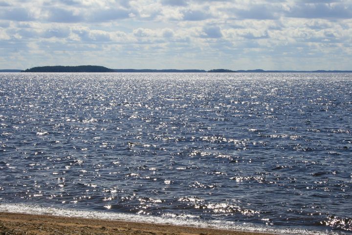 Järvimaisema Saimaalta, rauhallinen vesistö auringonpaisteessa.