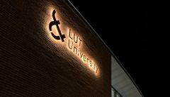 Logo LUT-yliopiston ulkoseinässä yöllä.