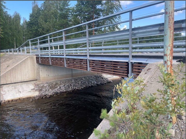 Pieni silta joen yllä vehreässä ympäristössä.