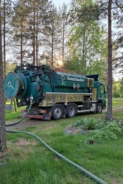 Viemärintyhjennysauto metsäisessä ympäristössä.