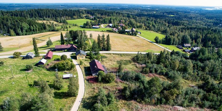 Ilmakuva maaseudusta, jossa on peltoja, taloja ja metsää.