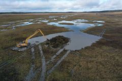 Ilmakuva kosteikosta jossa kaivinkone työskentelee parhaillaan.