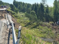 Sortunut tie metsän lähellä, kaiteet ovat vaurioituneet.